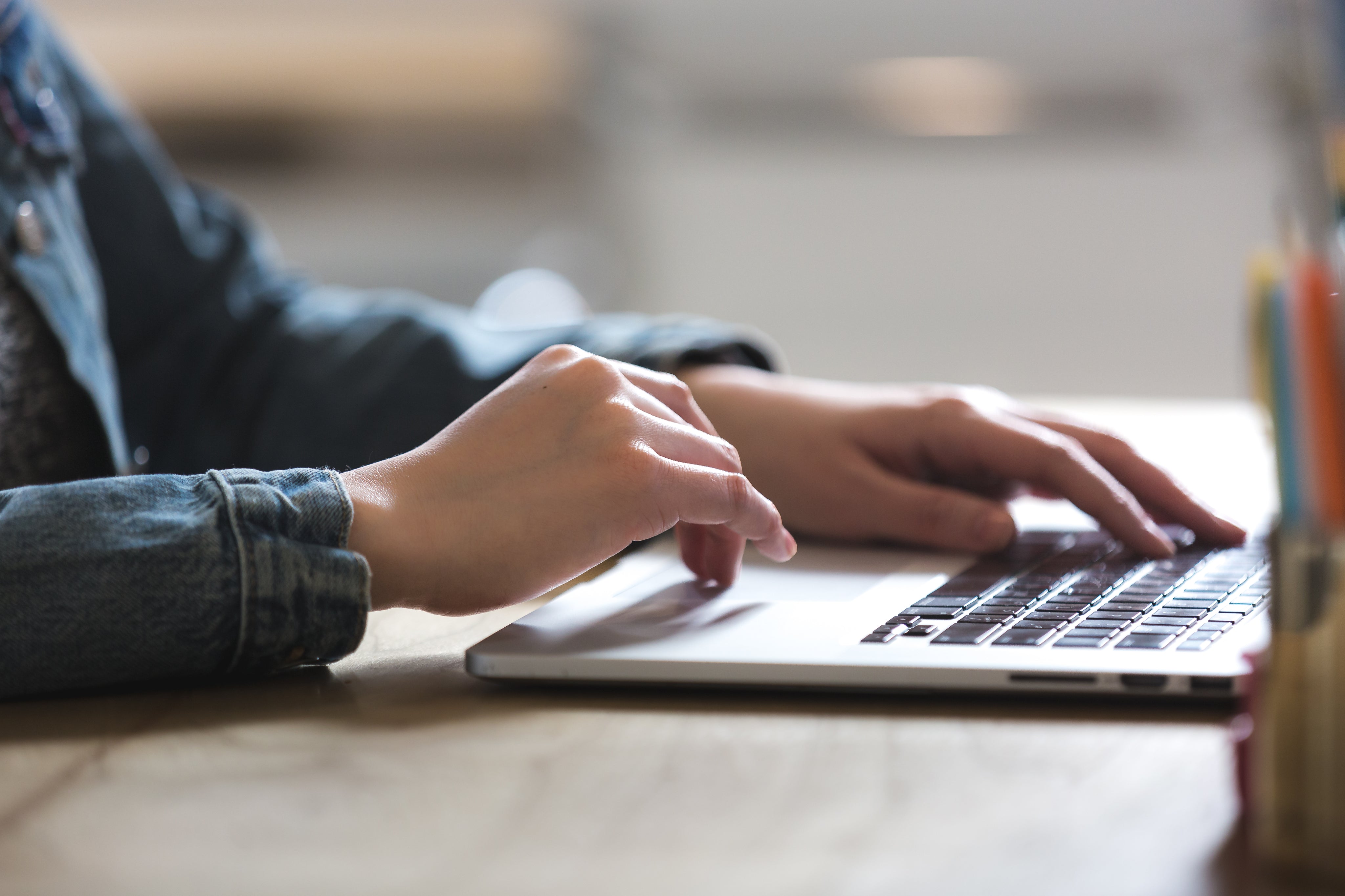 Co-Branding für Flaschen. Schreib uns einfach. Bild von einem Laptop. eine Person sitzt davor und schreibt etwas.